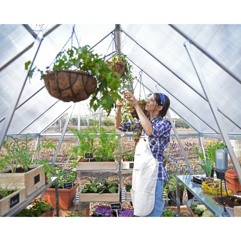 canopia-hybrid-greenhouse-woman-working-with-plant-hangers