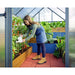 mythos-greenhouse-lifestyle-photo-girl-leaning-over-to-water-plants