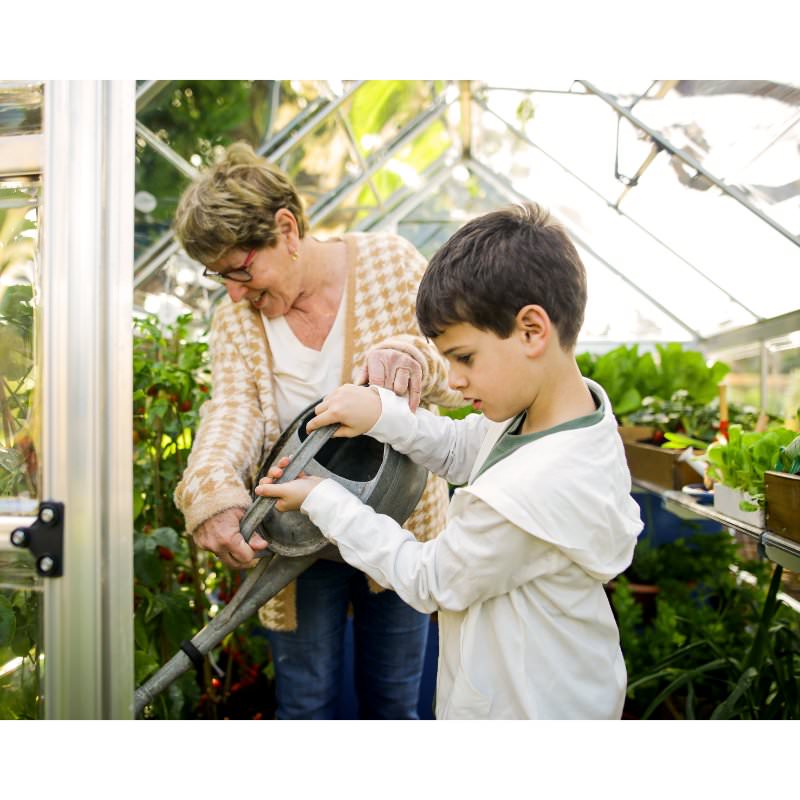 palram-canopia-hybrid-greenhouse-woman-and-kid-watering-plants