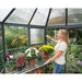 palram-oasis-hexagonal-greenhouse-12ft-woman-opening-louver-window