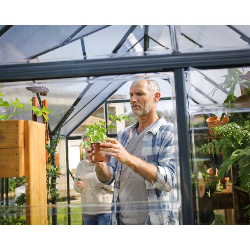 palram-victory-orangery-man-looking-at-plant